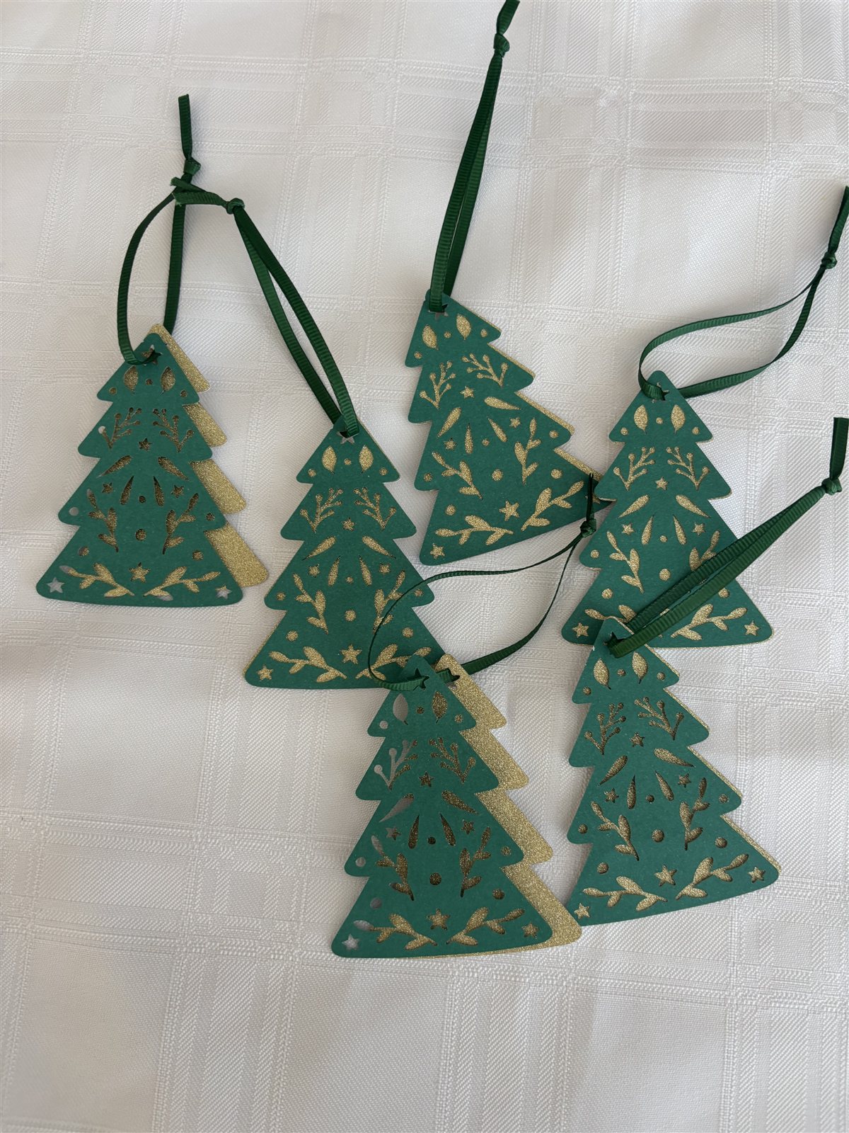 Six green Christmas-tree-shaped gift tags patterned with gold glitter
