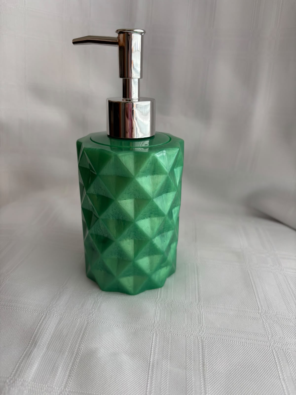 Faceted deep green resin soap dispenser with a metal pump