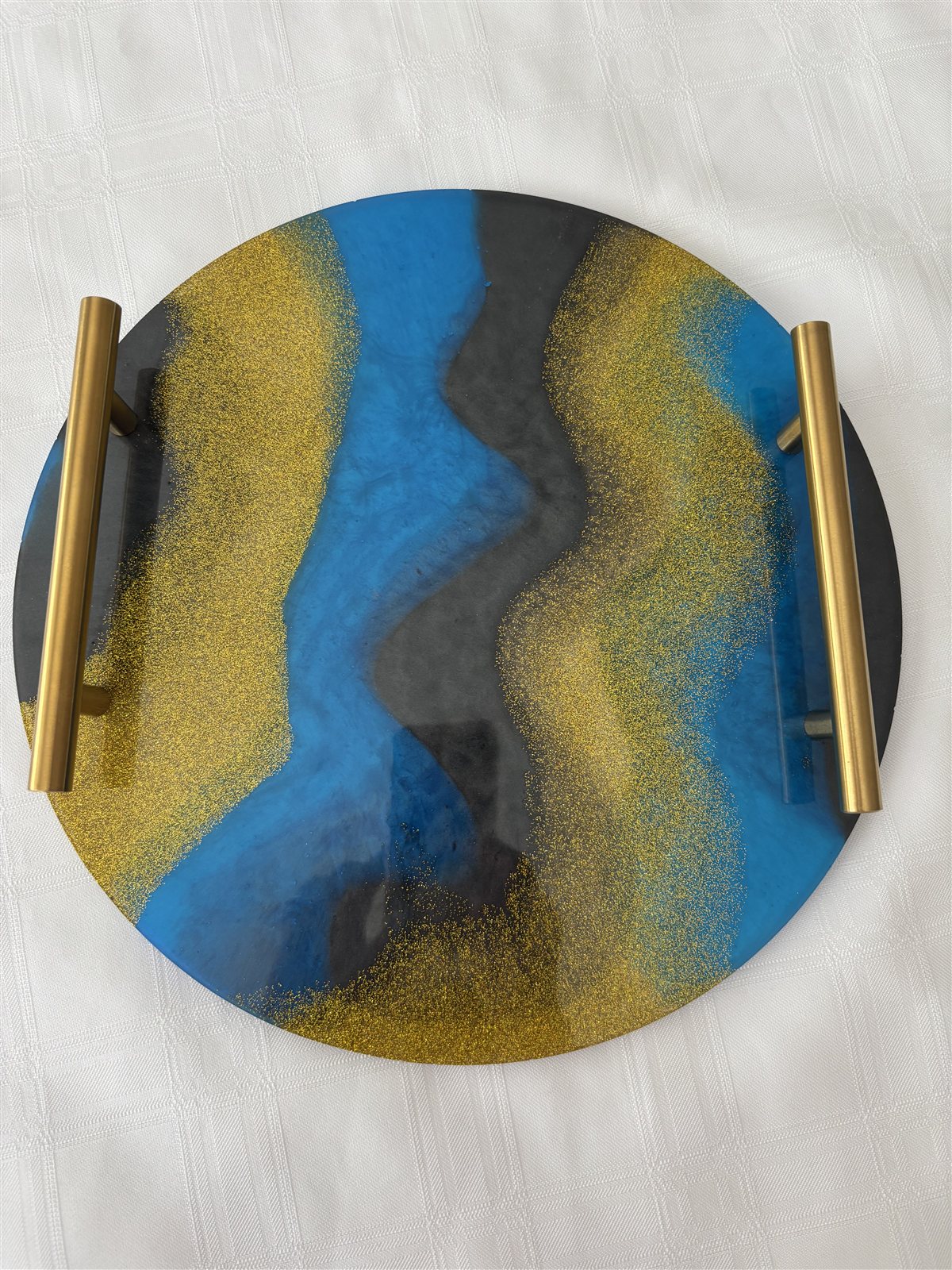 Round resin serving tray in ocean blue and charcoal with gold glitter and brass handles